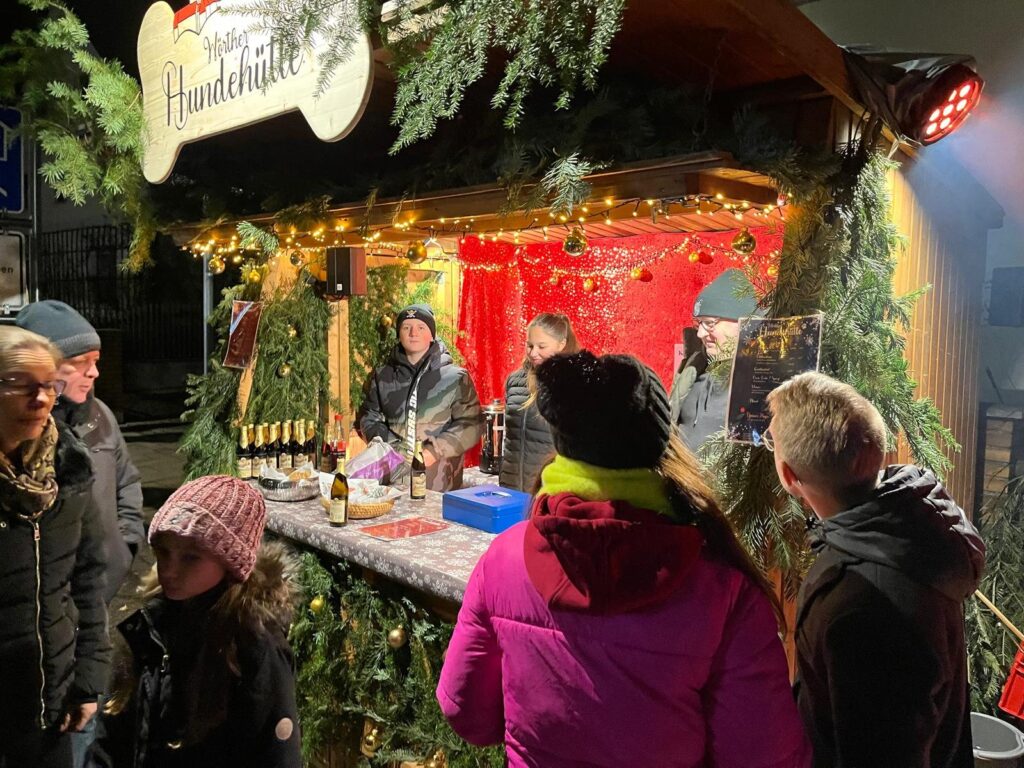 Besucherinnen und Besucher am beleuchteten Stand der SV OG Wörth