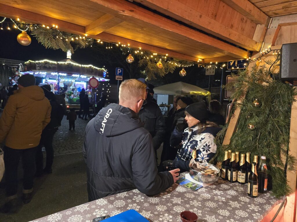 Gespräch zwischen einem Besucher und einer Helferin am abendlichen Vereinsstand